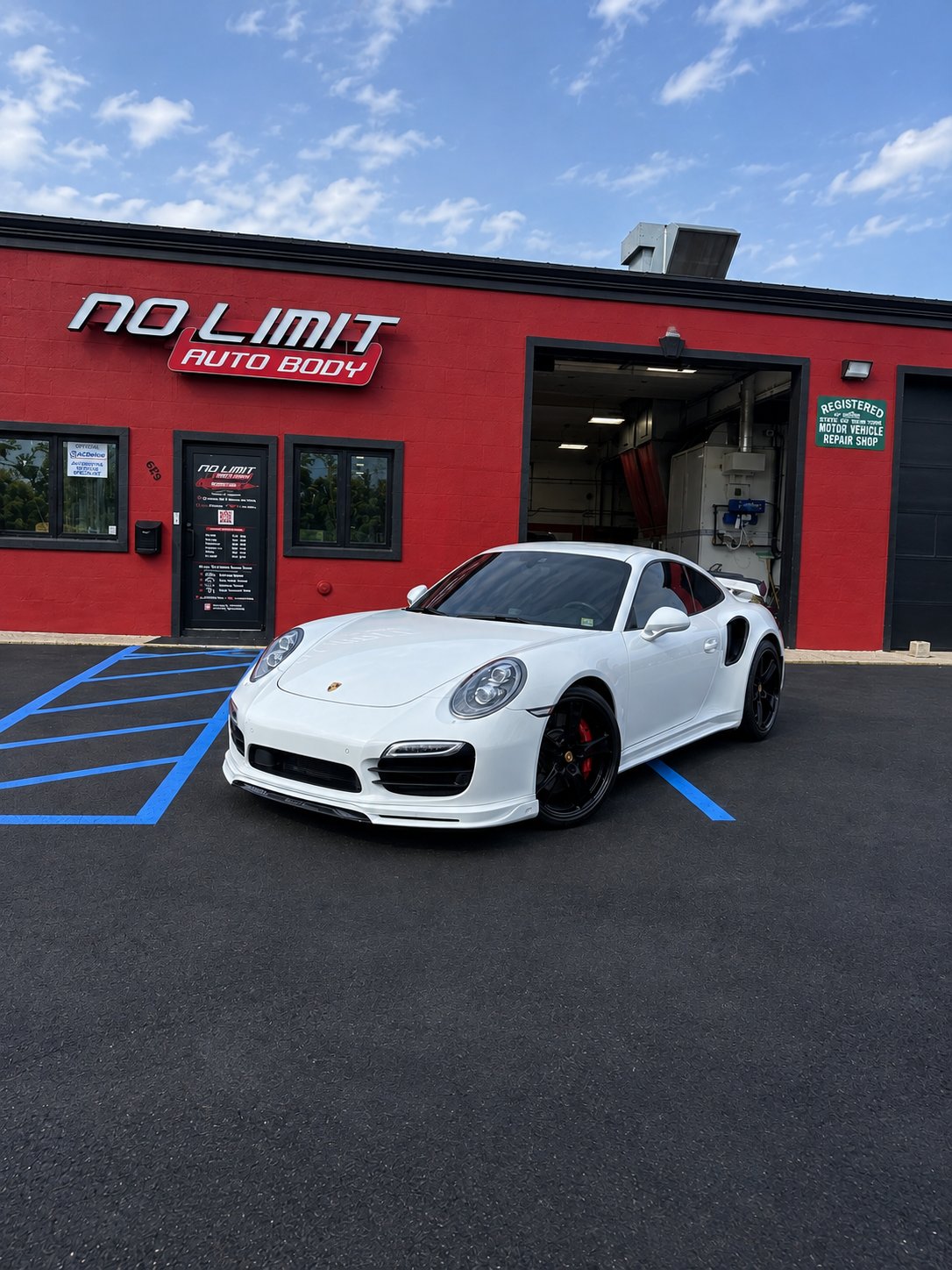 White Porsche 911 Turbo in front of the No Limit Auto Body shop