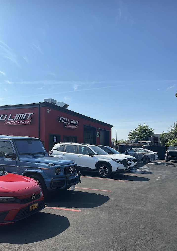 No Limit Auto Body storefront with customer vehicles in front
