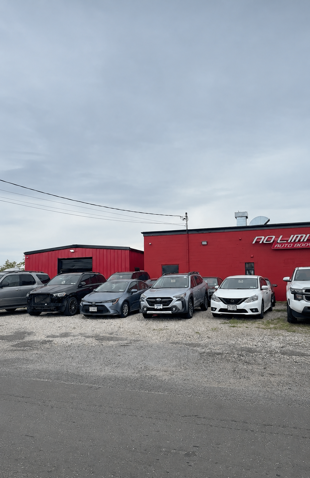 Exterior view of No Limit Auto Body building and front lot