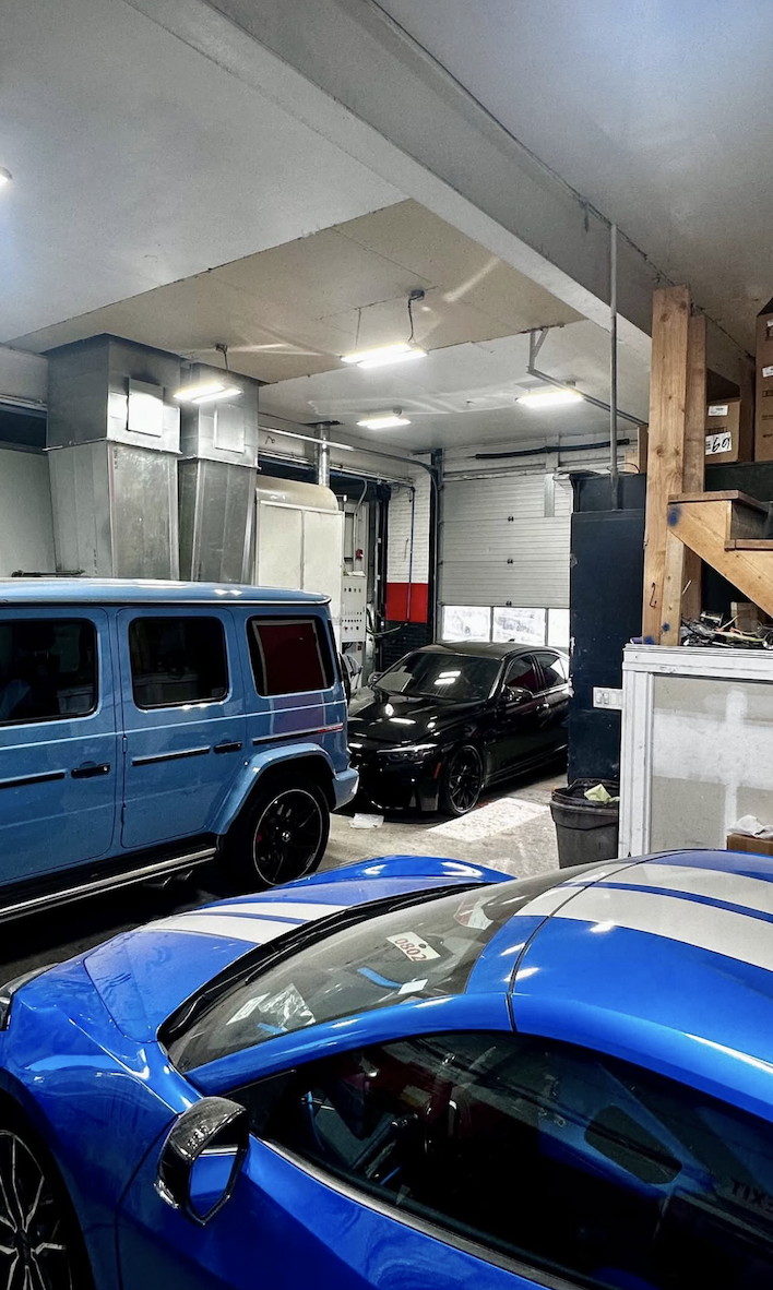 Interior service area with blue sports car and customer vehicles