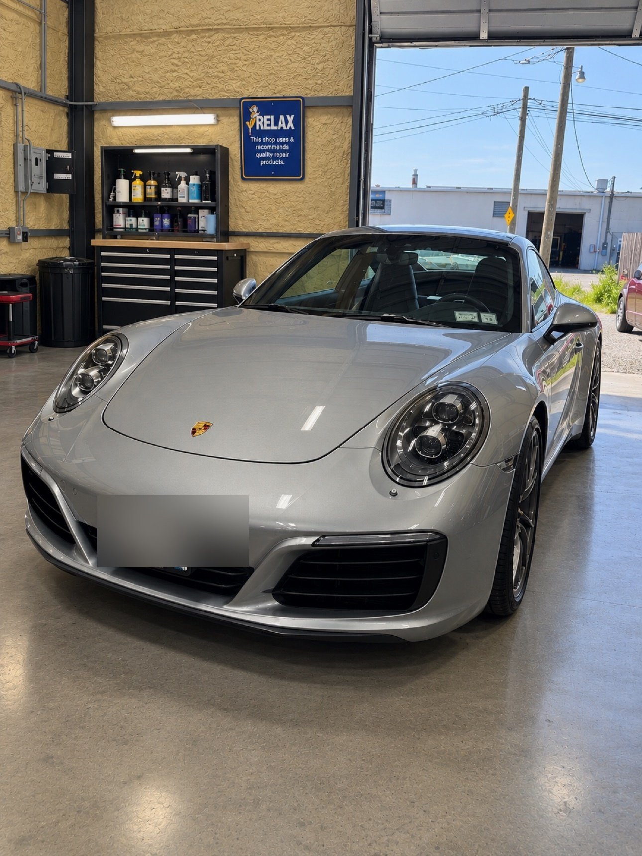 Silver Porsche 911 inside the No Limit Auto Body shop